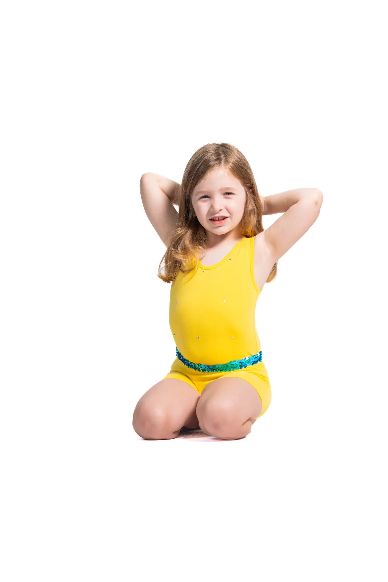 Young dancer in a yellow costume kneeling